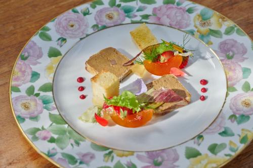 a plate with sandwiches and vegetables on a table at Castello Di Vicarello in Sasso dʼOmbrone