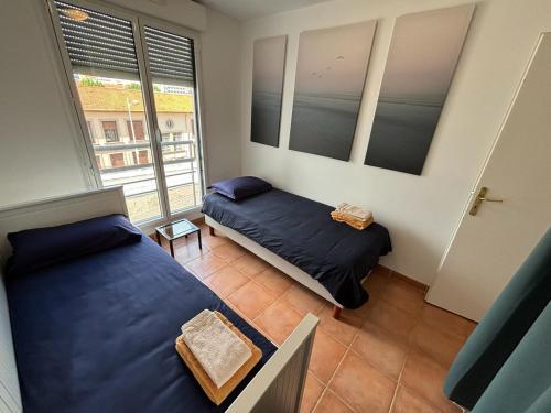 a bedroom with two beds and a window at Appartement Relaxant in Nice