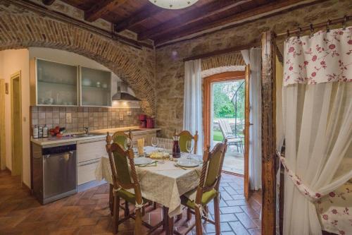 Rural Apartments Ritossa في Vižinada: مطبخ مع طاولة وكراسي في مطبخ