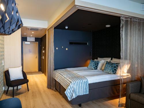 1 dormitorio con 1 cama grande y cabecero negro en Nallikari Holiday Village - Aalto Seaside Apartments, en Oulu