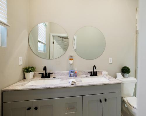 een badkamer met 2 wastafels en 2 spiegels bij Majestic House 3BRParking BBQ in Lithonia