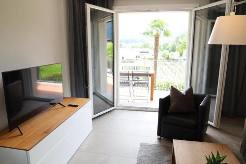a living room with a flat screen tv and a chair at Casa QUATTRO FIUMI in Tegna
