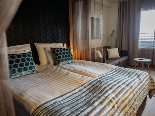 a bedroom with a large bed with a striped comforter at Nallikari Seaside Aalto Apartments in Oulu