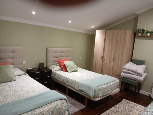 ビーゴにあるÁtico en Vigo playa Samilのベッドルーム1室(ベッド2台、キャビネット付)