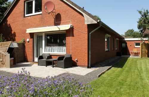 un patio con 2 sillas y una mesa frente a una casa en Ferienhaus für 4 Personen ca 110 qm in Risum-Lindholm, Schleswig-Holstein Kreis Nordfriesland, en Risum-Lindholm