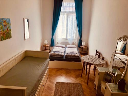 a bedroom with two beds and a table and a chair at Hostel Moravia Ostrava in Ostrava