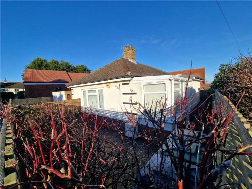 a white house with a chimney on top of a wall at 3 Harbord road in Cromer