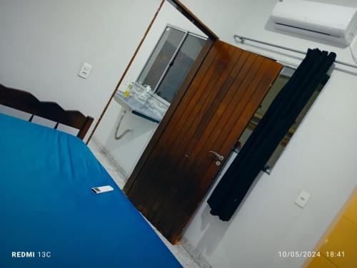 eine Holztür in einem Zimmer mit einem Bett in der Unterkunft Casa kitnet Próx da Rodoviária c/ suite e ar condicionado entrada individual . Geladeira e cozinha básica. Garagem pra carro. in Palmas