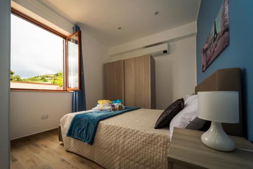 a bedroom with a bed with a lamp and a window at Casa Vacanze - Residence Villa Don Salvatore in Agropoli