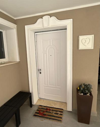 a white door in a room with a bench at Casa Morandi in San Vincenzo