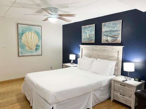 a bedroom with a white bed and a ceiling fan at Harmonious Suites in North Miami Beach