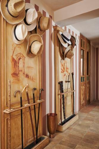 a hallway with hats hanging on a wall at Castello Di Vicarello in Sasso dʼOmbrone
