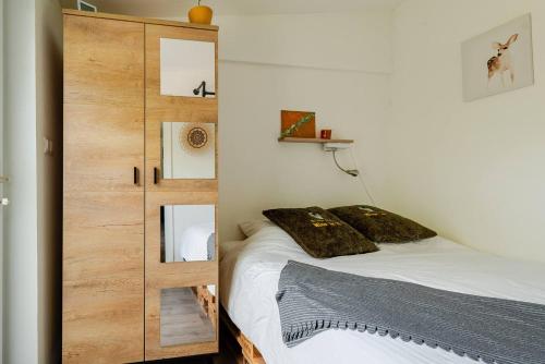 1 dormitorio con 1 cama y armario de madera en Tiny house - fietsverhuur, eigen keuken en badkamer en Nijmegen