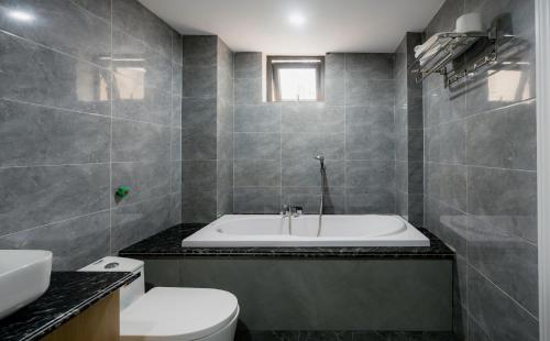 a bathroom with a tub and a toilet and a sink at Happy Villa Hạ Long in Ha Long