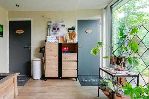 Habitación con vestidor y ventana grande. en Tiny house - fietsverhuur, eigen keuken en badkamer en Nijmegen
