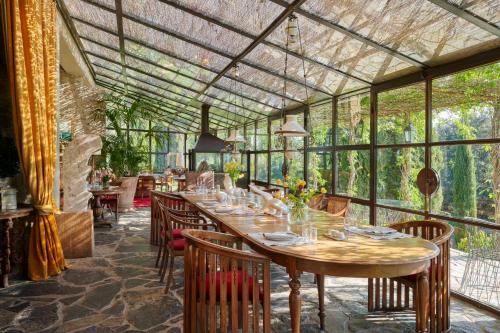 ein Esszimmer mit einem langen Tisch und einigen Fenstern in der Unterkunft Castello Di Vicarello in Sasso dʼOmbrone