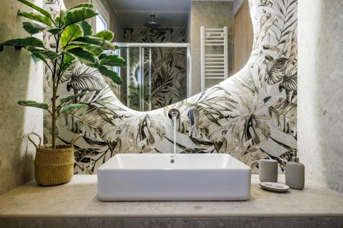 un bagno con lavandino bianco e pianta di Potoki Apartments a Skopelos Town