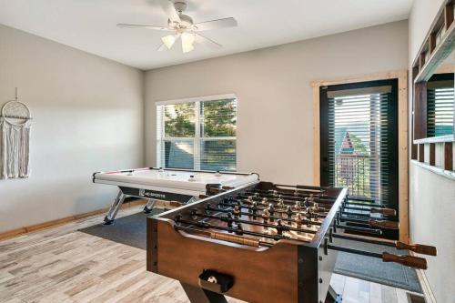 a living room with a pool table and a ceiling fan at Highland View Cabin in Pigeon Forge