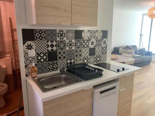une cuisine avec un évier et un plan de travail dans l'établissement Appartement cosy climatisé proche plage, à La Grande Motte
