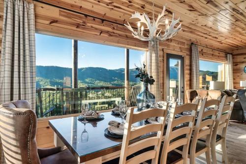 a dining room with a table and chairs and a large window at Highland View Cabin in Pigeon Forge