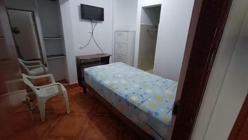 Urbanizacion Buenos Aires的住宿－House Yupanqui，一间卧室配有一张床、一把椅子和电视