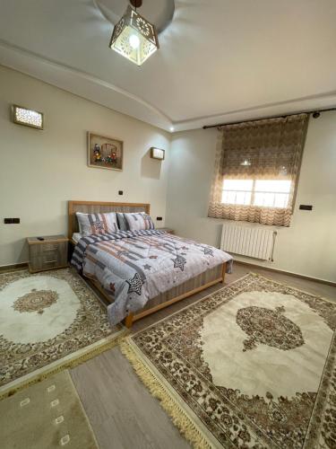 a bedroom with a bed and two rugs at Jaddou Home in Midelt