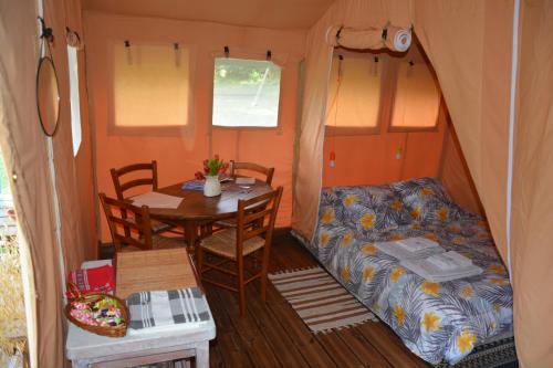 una casetta minuscola con un tavolo e un letto di La lodge face au lac a Sanssac-lʼÉglise