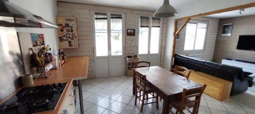 - une cuisine et une salle à manger avec une table et une cuisinière dans l'établissement Maison individuelle avec jardin, au calme, à Lorp Sentaraille
