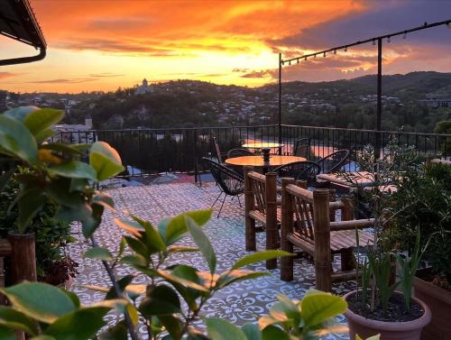 a patio with tables and chairs at sunset at Green Flower Hotel in Kutaisi