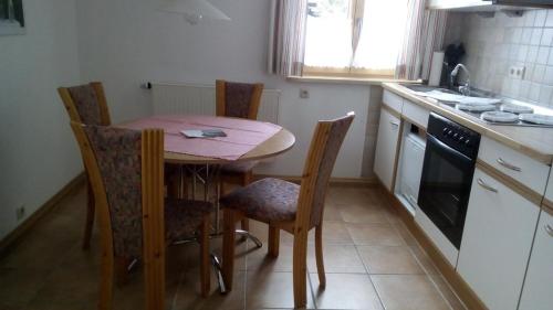 een keuken met een tafel en stoelen en een wastafel bij Gemütliche Ferienwohnung in Unterammergau mit Grill und Garten in Unterammergau