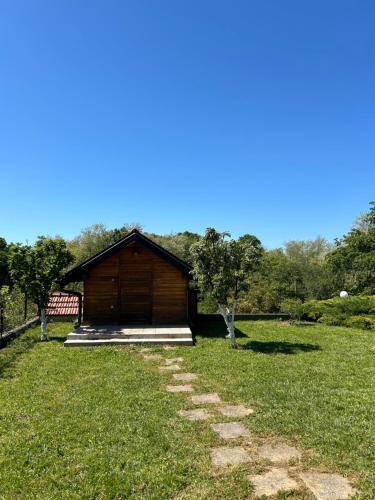 a log cabin in a field with a grass yard at Kuća Šuma in Velika Buna