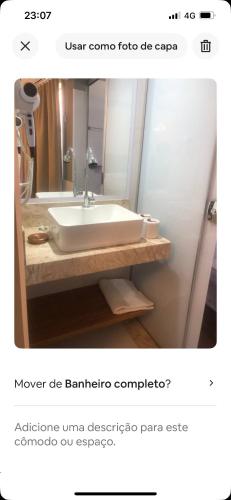 un baño con lavabo y espejo en Flat araras luxo, en Caldas Novas