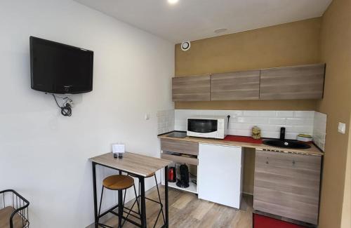 une petite cuisine avec une table et un micro-ondes dans l'établissement L'Aloe Vera, au Plan-de-la-Tour