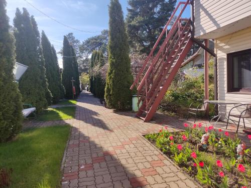 a brick walkway next to a house with trees at Hotel Veagles in Narva-Jõesuu