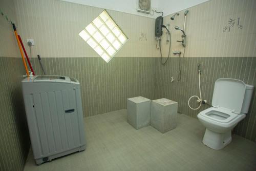 a bathroom with a toilet and a shower at koggala House By The Rock in Habaraduwa