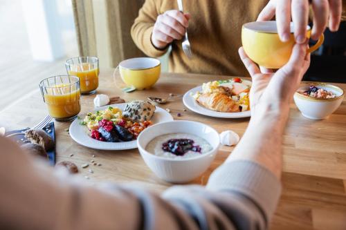 a group of people sitting at a table eating food at Nallikari Seaside Aalto Apartments in Oulu