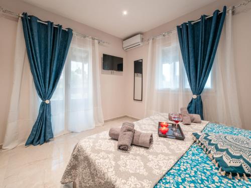 1 dormitorio con 1 cama con cortinas azules en THE VIEW HOUSE en Pelekas