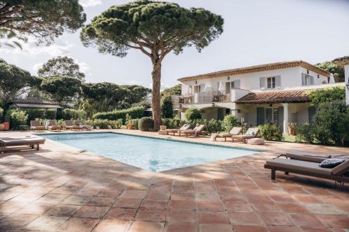 Bild eines Swimmingpools mit Stühlen und eines Hauses in der Unterkunft La Villa d'Andrea in Ramatuelle