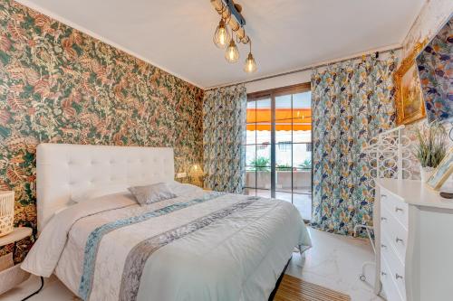 um quarto com uma cama e papel de parede floral em Lux and Cozy apartment em Los Cristianos