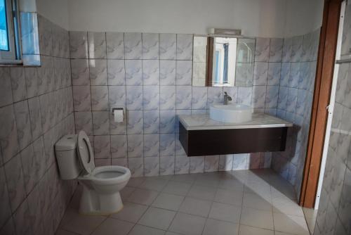 a bathroom with a toilet and a sink at Maison Stella Lome in Lomé