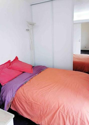 - un lit avec une couverture orange et violette dans l'établissement Appt T2 piscine / proche mer, à Vallauris
