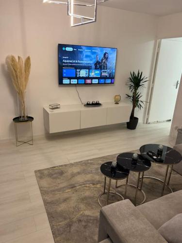 - un salon avec deux tables et une télévision à écran plat dans l'établissement Luxury Spa Appartement, à Mitry-Mory