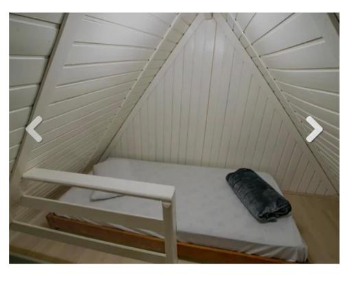 Una cama pequeña en una tienda con una almohada. en Chalé no Thermas Hot World, en Águas de Lindóia