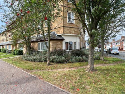 a brick house with trees in front of a street at Casa di Qeis a double bedroom ground floor flat with free parking in Chesterton