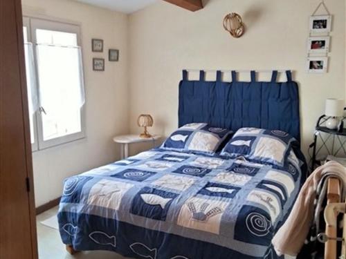 un lit bleu avec une couette bleue et blanche dans une chambre dans l'établissement Maison T3 avec mezzanine, jardin paysagé et parking privatif, à 1 km de la plage de Tanchet - FR-1-331-228, à Les Sables-dʼOlonne
