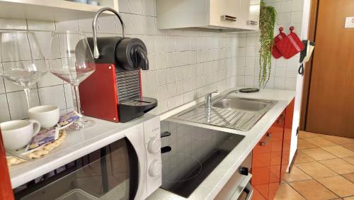 een keuken met een wastafel en een magnetron bij SanZenoHome StayInVerona Full Apartment in Verona