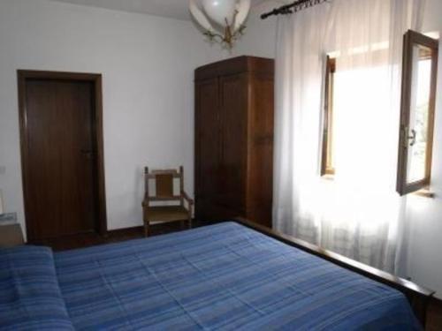 ein Schlafzimmer mit einem großen blauen Bett in einem Zimmer in der Unterkunft Studio für 3 Personen ca 60 qm in Fauglia, Toskana Etruskische Küste in Fauglia