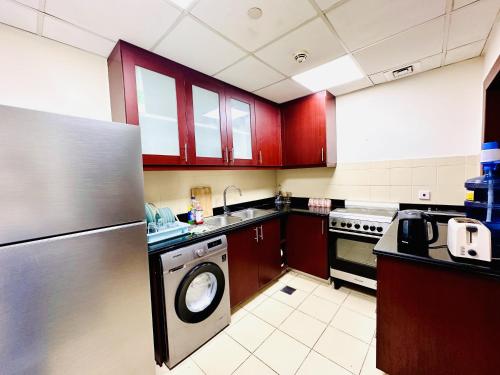 a kitchen with a dishwasher and a washer in it at The Aero Vacation Homes in Dubai