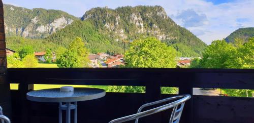 a table and two chairs on a balcony with mountains at Alpenhotel Gastager in Inzell