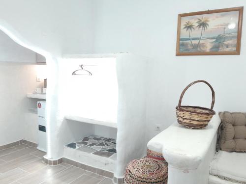 a room with a chair and a basket on the wall at Sunset Suite Annada No3 Arkasa in Arkasa